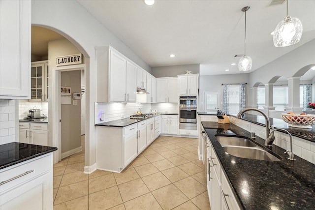 kitchen featuring backsplash, appliances with stainless steel finishes, a sink, white cabinets, and under cabinet range hood