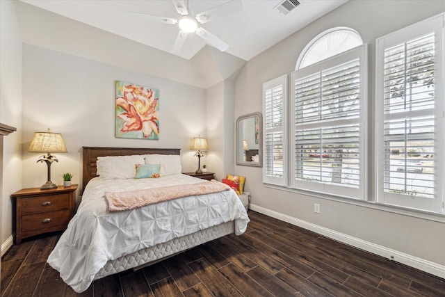 bedroom with visible vents, baseboards, wood finished floors, and multiple windows