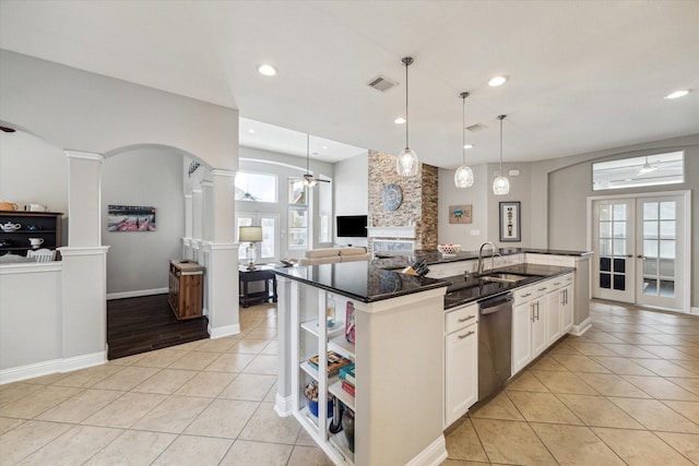 kitchen with decorative columns, light tile patterned flooring, arched walkways, a ceiling fan, and dishwasher