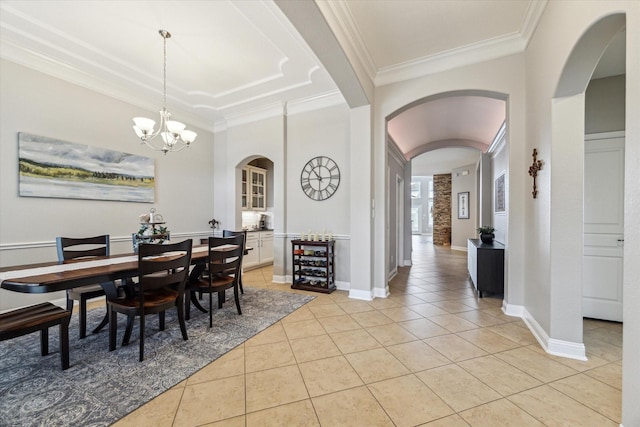 dining space featuring crown molding, arched walkways, and light tile patterned floors