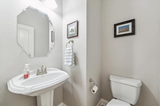 half bath with toilet and a sink