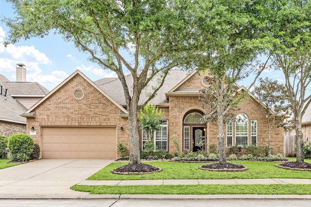 view of front of home with concrete driveway, brick siding, an attached garage, and a front yard