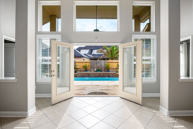 tiled foyer entrance featuring french doors, baseboards, and a towering ceiling
