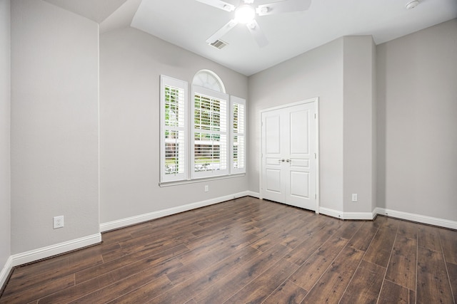 unfurnished bedroom with visible vents, baseboards, and dark wood-style floors