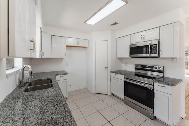 19822 Brightstone Dr, Humble, TX 77338 - kitchen with white cabinetry, visible vents, dark stone countertops, a sink, and stainless steel appliances