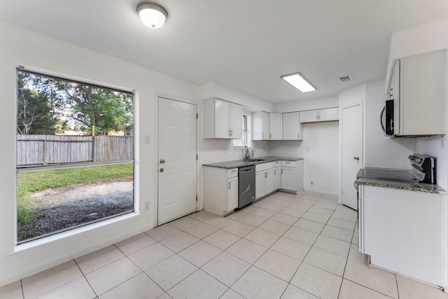 19822 Brightstone Dr, Humble, TX 77338 - kitchen with a sink, light tile patterned floors, white cabinets, and stainless steel appliances