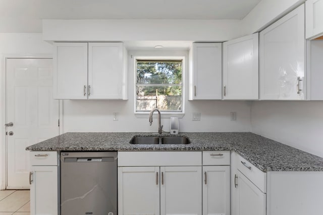 19822 Brightstone Dr, Humble, TX 77338 - kitchen featuring light tile patterned floors, white cabinets, dark stone counters, stainless steel dishwasher, and a sink