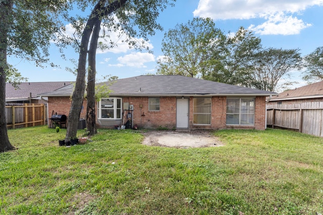 19822 Brightstone Dr, Humble, TX 77338 - rear view of house featuring a lawn, a fenced backyard, and brick siding