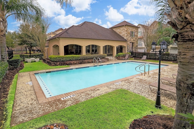 pool featuring a lawn and fence