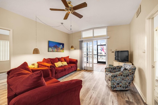 living area with baseboards, visible vents, wood finished floors, and ceiling fan