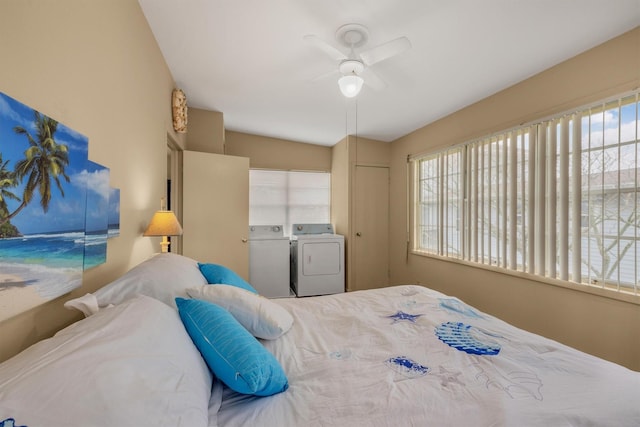 bedroom with a ceiling fan, washing machine and clothes dryer, multiple windows, and a closet
