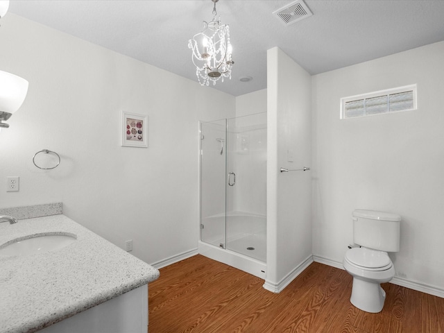 full bathroom with vanity, toilet, a shower stall, wood finished floors, and visible vents