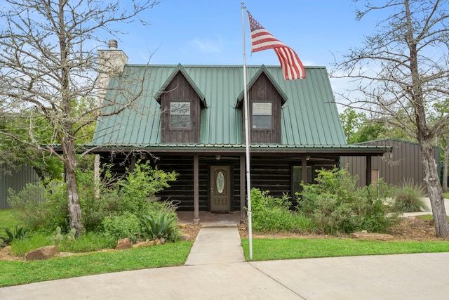 view of front facade featuring metal roof and a chimney