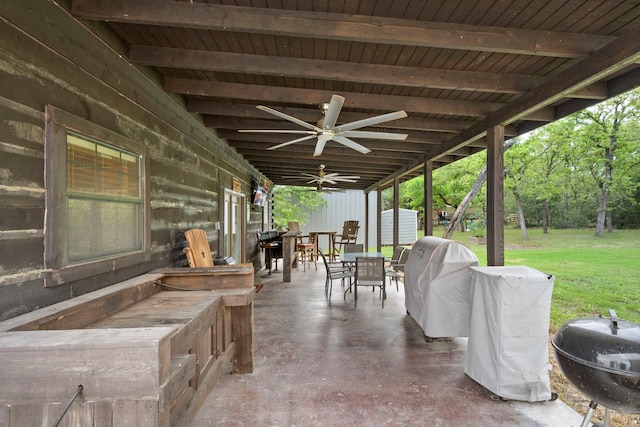 view of patio with outdoor dining area, an outdoor structure, area for grilling, and ceiling fan