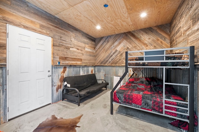 bedroom with concrete floors, wooden walls, and wood ceiling