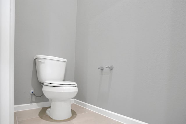 bathroom with tile patterned floors, baseboards, and toilet