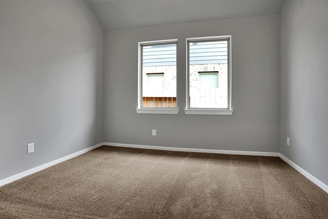 empty room with dark colored carpet and baseboards