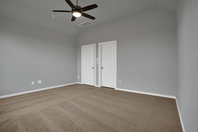 unfurnished bedroom featuring lofted ceiling, carpet flooring, visible vents, and baseboards