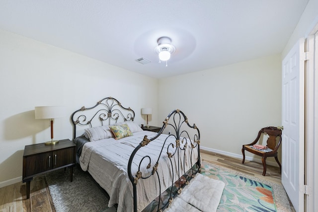 bedroom featuring wood finished floors, baseboards, and visible vents