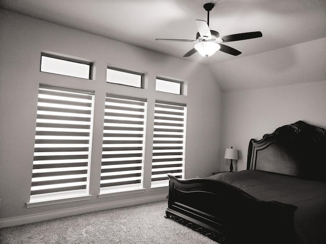 bedroom with vaulted ceiling, a ceiling fan, and carpet flooring