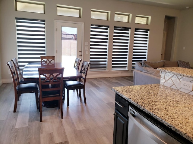 dining space featuring light wood-style floors and baseboards