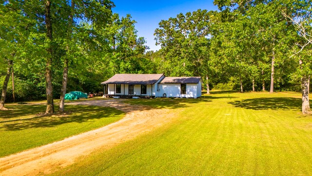 view of front of property with a front lawn and dirt driveway