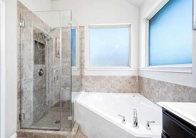 full bath with vanity, a garden tub, and a stall shower