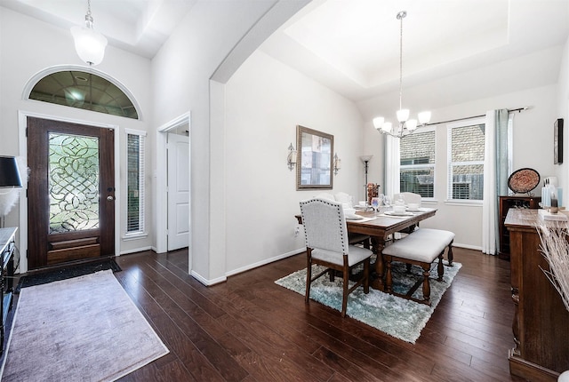 dining room with a healthy amount of sunlight, baseboards, dark wood-type flooring, and a notable chandelier