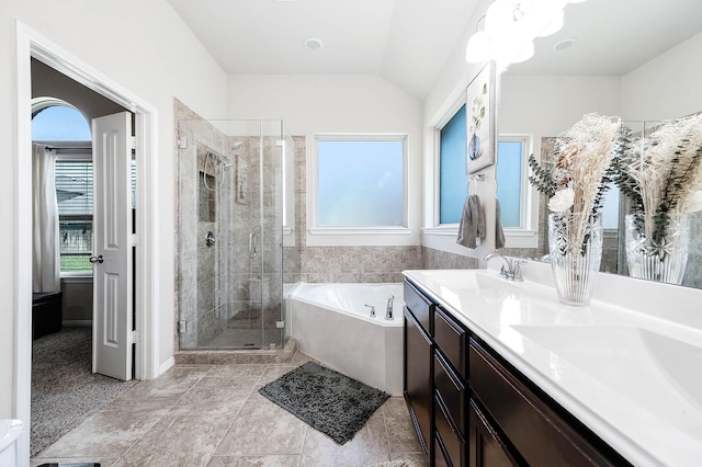 bathroom featuring double vanity, a shower stall, a healthy amount of sunlight, and a garden tub