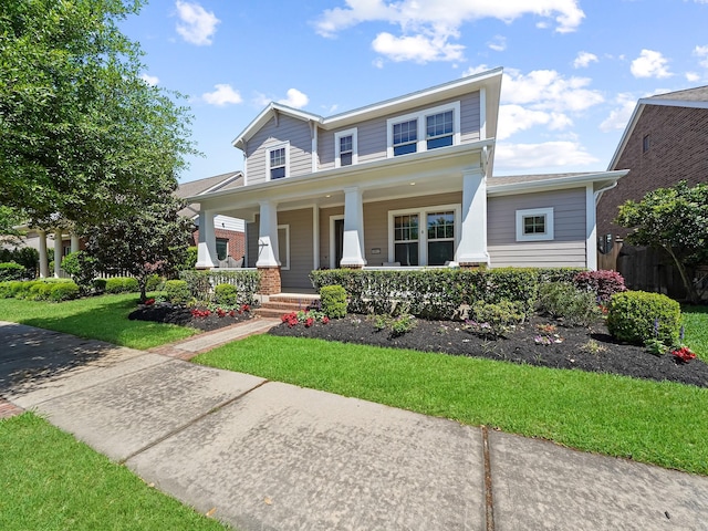 view of front of home with a porch and a front lawn