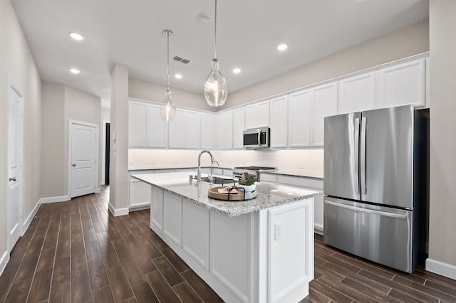 10723 Bridgeport Path Ct, Missouri City, TX 77459 - kitchen with visible vents, wood tiled floor, white cabinetry, a sink, and stainless steel appliances