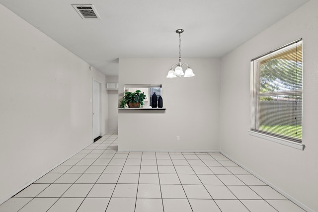 empty room featuring a chandelier, visible vents, baseboards, and light tile patterned flooring
