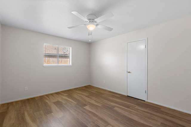 unfurnished room with ceiling fan, baseboards, and wood finished floors
