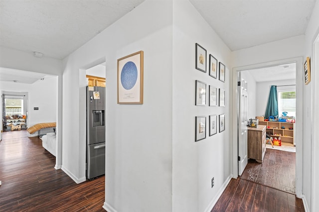 hallway featuring baseboards and dark wood-type flooring