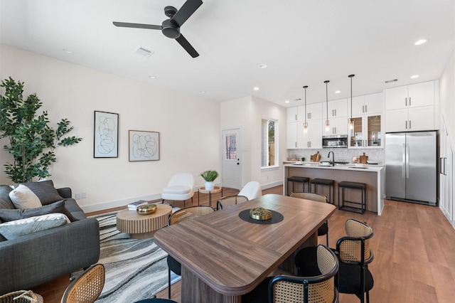 living area featuring recessed lighting, light wood-style flooring, visible vents, and a ceiling fan