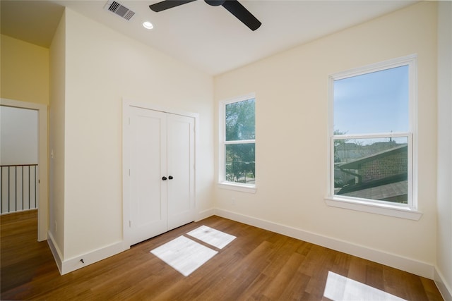 unfurnished bedroom featuring visible vents, baseboards, and wood finished floors