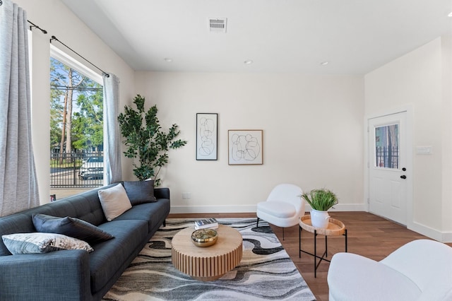 living area with wood finished floors, baseboards, visible vents, and recessed lighting