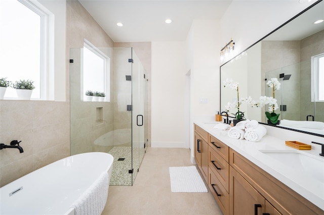 full bathroom featuring a freestanding bath, double vanity, a sink, and a stall shower