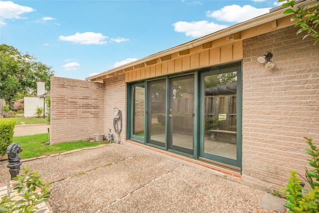 45 Champions Colony E, Houston, TX 77069 - doorway to property featuring brick siding, a patio, and board and batten siding