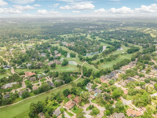 drone / aerial view with a water view, view of golf course, and a residential view