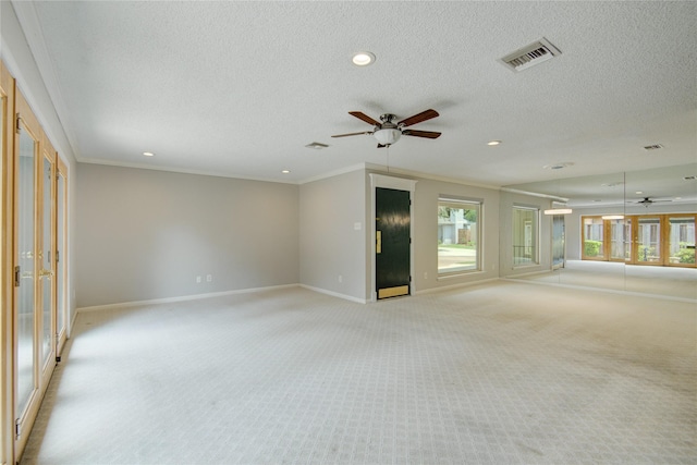 empty room with baseboards, ceiling fan, light carpet, and visible vents