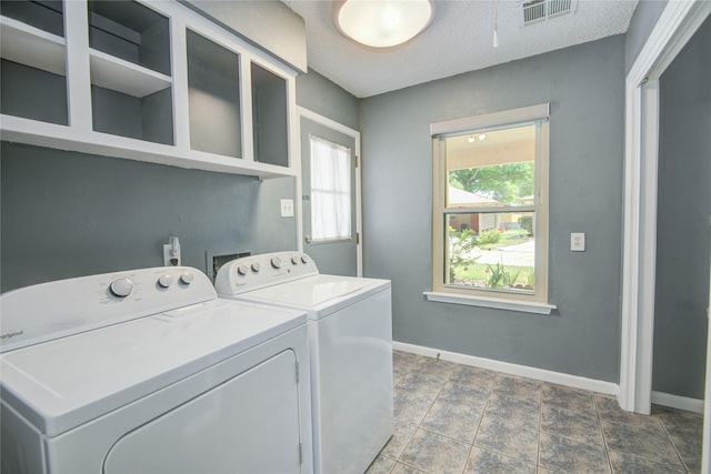 clothes washing area with laundry area, a textured ceiling, visible vents, baseboards, and separate washer and dryer