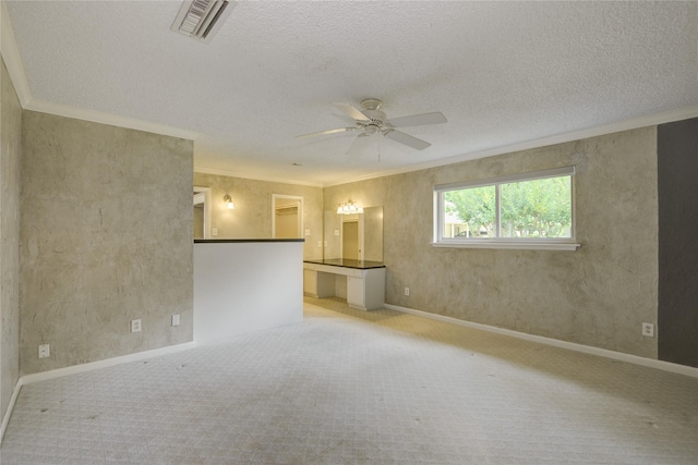 empty room with visible vents, baseboards, ceiling fan, light colored carpet, and a textured ceiling