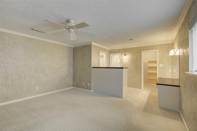 unfurnished room with ceiling fan, ornamental molding, carpet flooring, and visible vents
