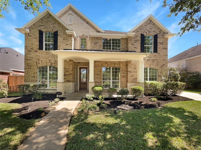 7206 Fiesta Flower, Katy, TX 77494 - traditional home featuring a porch, a front yard, fence, and brick siding