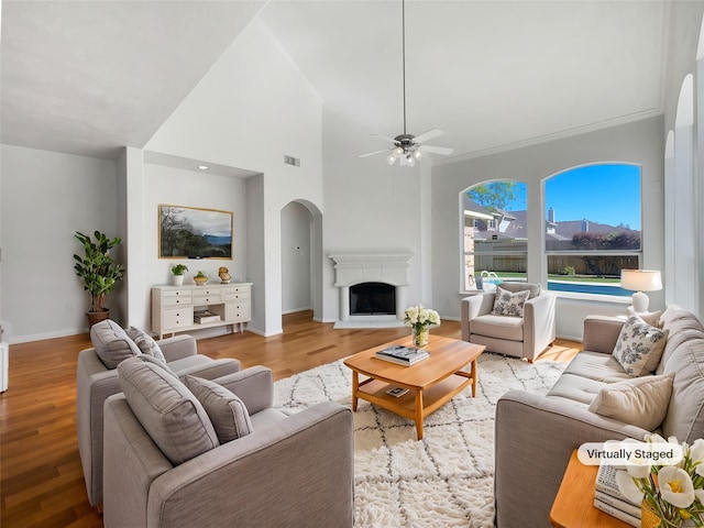 7206 Fiesta Flower, Katy, TX 77494 - living room featuring arched walkways, a ceiling fan, a fireplace with raised hearth, visible vents, and light wood finished floors