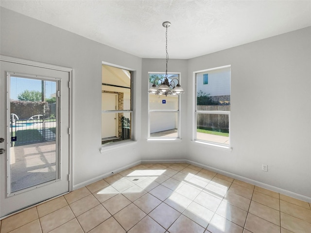 7206 Fiesta Flower, Katy, TX 77494 - unfurnished dining area with light tile patterned floors, baseboards, and an inviting chandelier