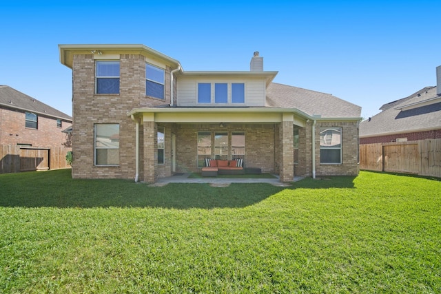back of property with outdoor lounge area, a chimney, brick siding, and a patio area