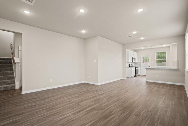 302 Elk Run Ln, Huntsville, TX 77320 - unfurnished living room featuring dark wood-style flooring, recessed lighting, stairway, and baseboards