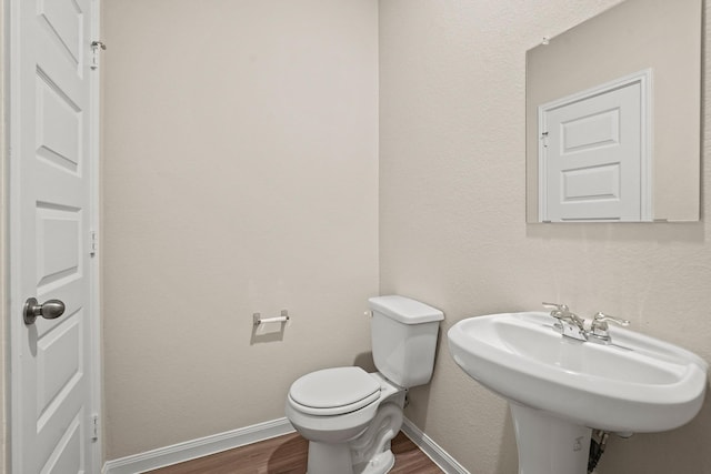 302 Elk Run Ln, Huntsville, TX 77320 - half bathroom featuring toilet, a sink, wood finished floors, and baseboards